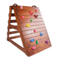 Large wooden climbing wall, with multi coloured climbing holds. 